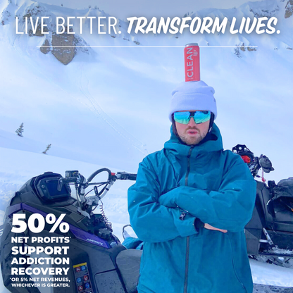 A man standing in front of a snowmobile on the side of a mountain with a Watermelon Mint CLEAN Cause Yerba Mate on his head with the slogan Live Better. Transform Lives. above her and 50% Net profits* support addiction recovery *or 5% net revenues, whichever is greater