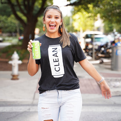 Woman wearing grey t-shirt with white CLEAN cause can image on front with white jeans holding a Lemon Lime CLEAN can in her right hand.